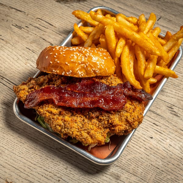 Brooklyn Wing Company's crispy chicken sandwich with bacon and fries on a metal tray.